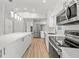 Bright, all-white kitchen featuring stainless steel appliances, modern countertops, and a large center island at 7912 Estates Dr, Sarasota, FL 34243