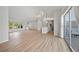 Open-concept living space features modern lighting, wood floors, and seamless flow to kitchen and outdoor pool area at 7912 Estates Dr, Sarasota, FL 34243