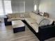 Bright living room featuring a wicker sectional sofa with an ottoman at 7912 Estates Dr, Sarasota, FL 34243