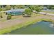 Aerial view of a house with enclosed pool backing to a small pond at 7912 Estates Dr, Sarasota, FL 34243