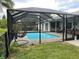 Spacious pool with an extended cage and seating area for relaxation and entertainment at 7912 Estates Dr, Sarasota, FL 34243