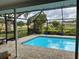 Inviting screened-in pool area with brick patio and string lights, perfect for outdoor entertaining at 7912 Estates Dr, Sarasota, FL 34243
