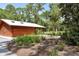 Exterior shot of a restroom building with a metal roof surrounded by natural landscaping at 7912 Estates Dr, Sarasota, FL 34243