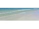 Serene beach scene with gentle waves lapping against the sandy shore at 8001 20Th W Pl, Bradenton, FL 34209