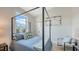Well-lit bedroom with four poster bed, light wood floors and wainscotting at 8001 20Th W Pl, Bradenton, FL 34209