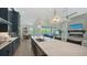 Bright open kitchen featuring marble countertops, an island bar, and modern fixtures flowing into living spaces at 8001 20Th W Pl, Bradenton, FL 34209