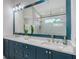 The main bathroom features a large mirror over a blue dual sink vanity, with a shower and bathtub visible at 8001 20Th W Pl, Bradenton, FL 34209