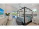 A stunning main bedroom offers a four-poster bed, an outdoor view of the pool, and modern furniture at 8001 20Th W Pl, Bradenton, FL 34209