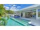 Backyard pool and jacuzzi surrounded by lush tropical landscaping and outdoor kitchen at 8001 20Th W Pl, Bradenton, FL 34209