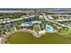 Stunning aerial view of community amenities including clubhouse, pool, and lakefront homes with lush landscaping at 8229 Grande Shores Dr, Sarasota, FL 34240