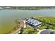 Attractive aerial view of lakefront community clubhouse, surrounded by water, lush greenery, and a private dock at 8229 Grande Shores Dr, Sarasota, FL 34240