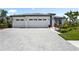 Beautiful home exterior with a three-car garage and manicured landscaping at 8229 Grande Shores Dr, Sarasota, FL 34240
