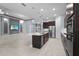 Spacious kitchen open to living area, featuring dark cabinetry and stainless steel appliances at 8229 Grande Shores Dr, Sarasota, FL 34240