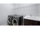 Laundry room with front load washer and dryer, a utility sink, and storage space at 8229 Grande Shores Dr, Sarasota, FL 34240