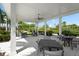 Outdoor patio area with a covered seating area with fan and multiple tables and chairs for enjoying the outdoors at 8229 Grande Shores Dr, Sarasota, FL 34240