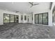 Spacious outdoor patio, enhanced by ceiling fans, featuring access doors and views of the screened in pool at 8229 Grande Shores Dr, Sarasota, FL 34240