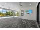 Relaxing outdoor patio, featuring neutral pavers, a ceiling fan and TV, perfect for lounging by the screened pool at 8229 Grande Shores Dr, Sarasota, FL 34240