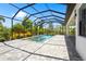 Screened pool and patio enhanced by lush landscaping, a spa, and sunny skies, creating a private outdoor oasis at 8229 Grande Shores Dr, Sarasota, FL 34240