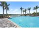 Serene pool with fountain features, deck chairs and umbrellas, surrounded by landscaping and palm trees at 8229 Grande Shores Dr, Sarasota, FL 34240