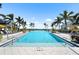 Resort-style swimming pool with palm trees, lounge chairs, and umbrellas, perfect for relaxation at 8229 Grande Shores Dr, Sarasota, FL 34240