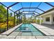 Inviting screened pool featuring a spa, and ample lounge space for relaxation with views of the manicured backyard at 8229 Grande Shores Dr, Sarasota, FL 34240