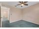 Cozy bedroom featuring neutral colored walls, blue carpet, and a ceiling fan at 835 70Th E Dr, Sarasota, FL 34243