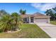 Inviting single-story home with manicured lawn and decorative palm tree landscaping at 835 70Th E Dr, Sarasota, FL 34243