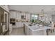 Modern kitchen featuring stainless steel appliances, a large island, white cabinets, and an adjacent dining area at 8579 Big Dipper Dr, Sarasota, FL 34241