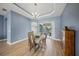 A formal dining room with an elegant chandelier, wood floors, a table with four chairs, and access to the porch at 9106 Yarberry St, Sarasota, FL 34240