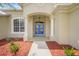 A close-up of the main entrance, highlighting a covered entryway, decorative columns, and a vibrant front door with sidelights at 9106 Yarberry St, Sarasota, FL 34240