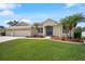 Picture-perfect single-Gathering home with a manicured lawn, three-car garage, vibrant garden beds, and an attractive entryway at 9106 Yarberry St, Sarasota, FL 34240