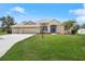 Inviting single-Gathering home featuring a spacious lawn, three-car garage, lush landscaping, and a welcoming covered entrance at 9106 Yarberry St, Sarasota, FL 34240
