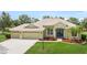 Lovely single-Gathering home featuring a three-car garage, colorful flowerbeds, meticulously kept lawn, and an inviting entryway at 9106 Yarberry St, Sarasota, FL 34240