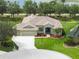 Charming single-Gathering home featuring a well-manicured lawn, three-car garage, mature trees, and a welcoming covered entrance at 9106 Yarberry St, Sarasota, FL 34240