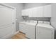This laundry room features a washer, dryer, cabinets, and sink at 9106 Yarberry St, Sarasota, FL 34240