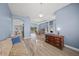 Spacious living room with view to dining room and kitchen, light blue walls and wood floors at 9106 Yarberry St, Sarasota, FL 34240