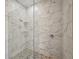 Elegant shower with marble-look tile and a glass door in a modern bathroom at 9106 Yarberry St, Sarasota, FL 34240