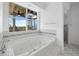 Elegant bathroom with a large soaking tub, separate shower, and a view of the outdoors at 9315 9Th Nw Ave, Bradenton, FL 34209