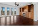 Cozy living room with hardwood floors, a fireplace, built-in cabinets, and access to an outdoor deck at 9315 9Th Nw Ave, Bradenton, FL 34209