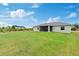 Large grassy backyard with a screened lanai offering a serene outdoor living space at 9601 Calumet Blvd, Port Charlotte, FL 33981