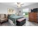 Cozy bedroom with dark wood dresser, upholstered bench, and gray wood flooring offering relaxation and functionality at 9601 Calumet Blvd, Port Charlotte, FL 33981