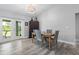 Bright dining room with a table set for four, wood look tile, and a sliding glass door to the patio at 9601 Calumet Blvd, Port Charlotte, FL 33981