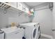 Functional laundry room featuring storage shelves, utility sink, and modern washer and dryer for added convenience at 9601 Calumet Blvd, Port Charlotte, FL 33981