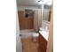 Cozy bathroom features tiled floors, a shower-tub combo, and a single sink vanity with updated fixtures and finishes at 9835 El Camino Real Ave, Port Richey, FL 34668
