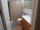 Bathroom with tiled floors, shower-tub combo, single sink vanity, and updated fixtures creating a functional and appealing space at 9835 El Camino Real Ave, Port Richey, FL 34668