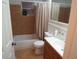 Cozy bathroom features tiled floors, a shower-tub combo, and a single sink vanity with updated fixtures and finishes at 9835 El Camino Real Ave, Port Richey, FL 34668