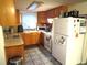 Functional kitchen featuring stainless steel appliances, light wood cabinets, and tiled floors, complemented by natural lighting at 9835 El Camino Real Ave, Port Richey, FL 34668