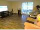 Spacious living room with wood floors, large windows, and comfortable seating area at 9835 El Camino Real Ave, Port Richey, FL 34668