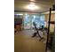 Enclosed sun room area with windows and an exercise bike, offering a flexible space for recreation or relaxation at 9835 El Camino Real Ave, Port Richey, FL 34668