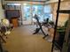 Enclosed sun room area with windows and an exercise bike, offering a flexible space for recreation or relaxation at 9835 El Camino Real Ave, Port Richey, FL 34668